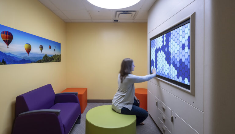 A person does a calming exercise on a touchscreen in a Mayo Clinic psych department sensory room.