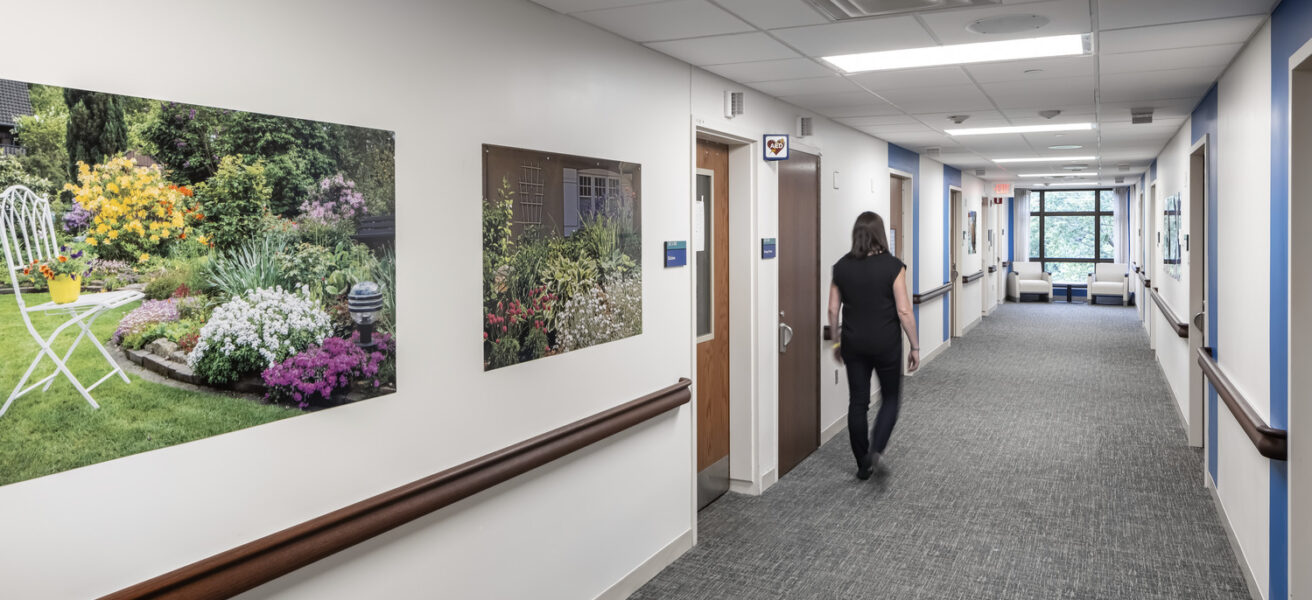 A person walks down a Mayo Clinic psych department corridor, accompanied by wall artwork.