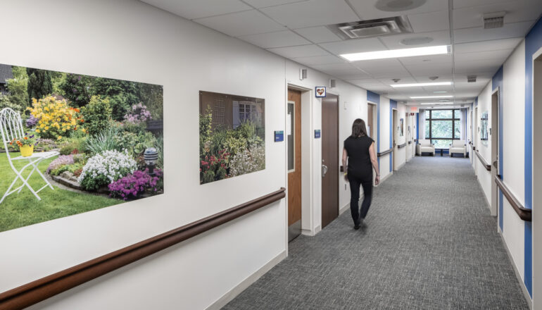 A person walks down a Mayo Clinic psych department corridor, accompanied by wall artwork.