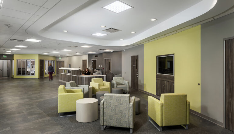 A yellow-themed behavioral health unit with comfortable furniture and clear sightlines