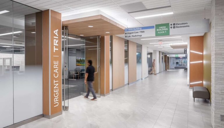 Interior corridor leading to Tria Urgent Care and additional services.