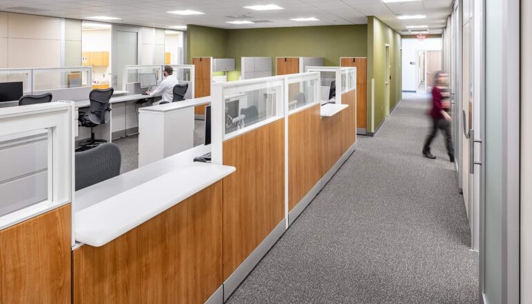 A nurse station with wood paneling and easy access to patient rooms.