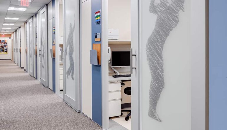 The orthopedic exam corridor with sports graphic film coverings on sliding exam room doors.