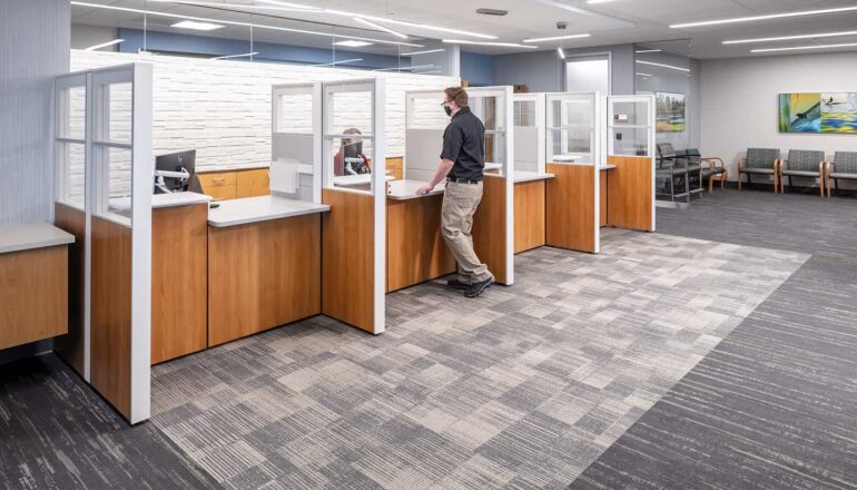 Clinic registration desks with wood paneling and calming gray and blue color palette.