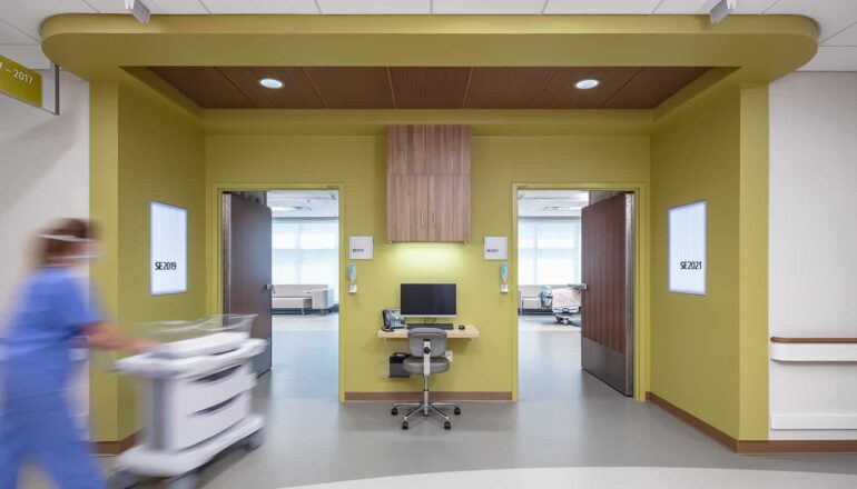 View from the corridor into two post op rooms with green entry wayfinding.