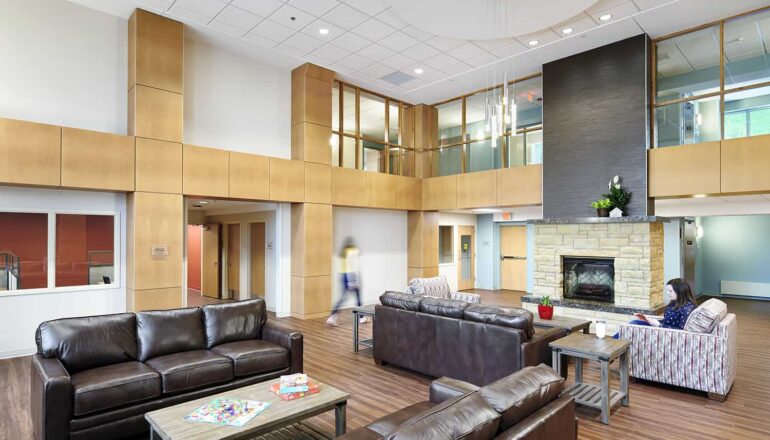 Overall view of the main shared living area, with homey furniture and a fireplace.