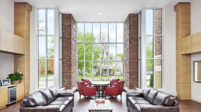 Shared open living space with floor to ceiling windows that let in daylight and views to the neighborhood.