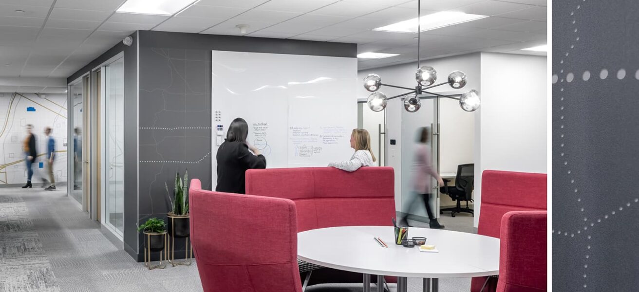 A touchdown station with brightly colored furniture and a whiteboard for collaboration.