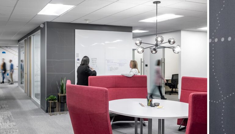 A touchdown station with brightly colored furniture and a whiteboard for collaboration.