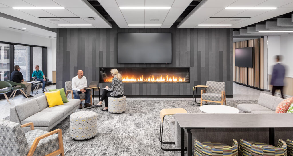 People collaborate and work in the Securian lounge with a fireplace
