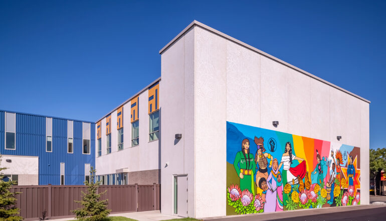 View to the side and back of the social services headquarters featuring a colorful neighborhood mural.