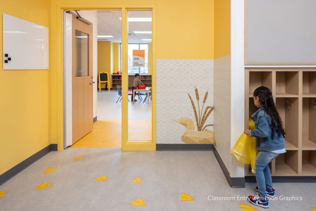 A child using the storage cubby outside of the Loon Classroom.