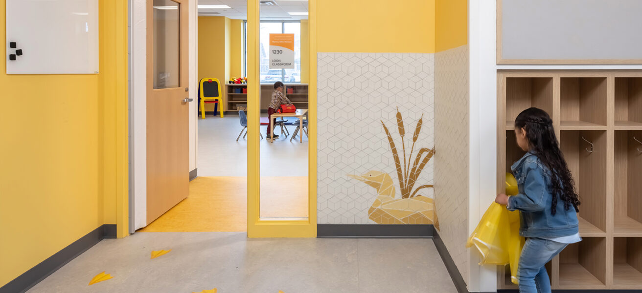 A child using the storage cubby outside of the Loon Classroom.