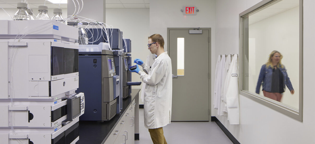 A person performs tests in a Tapemark cleanroom.