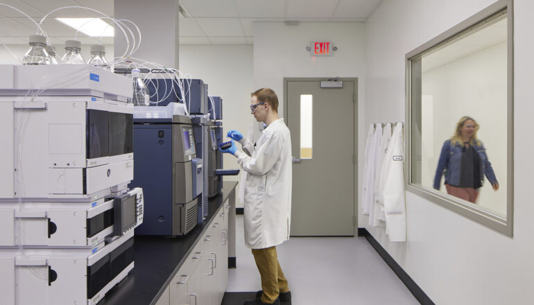 A person performs tests in a Tapemark cleanroom.