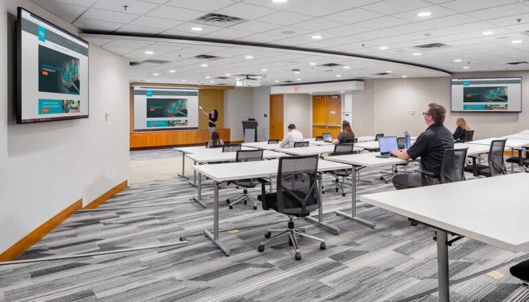A large conference room with multiple monitors throughout the room.