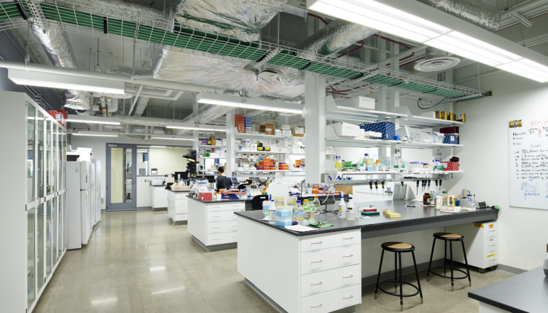 A biological sciences lab is filled with lab equipment and bright lighting