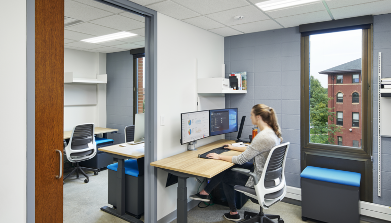 A faculty member works at one of the new office stations in the Biological Sciences Center, with close proximity to other faculty and researchers