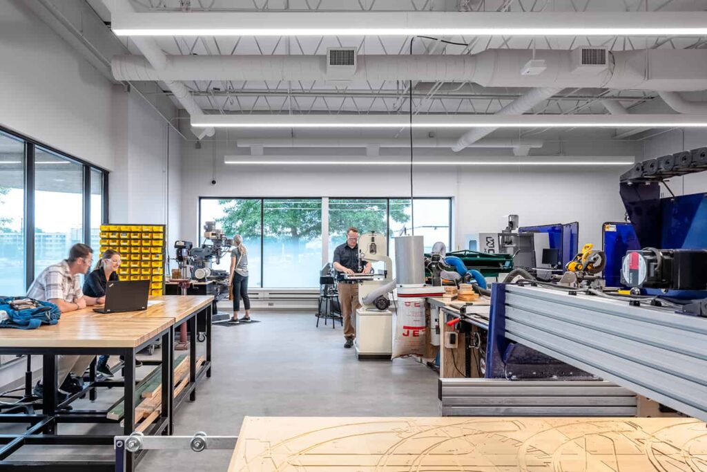 A student engineering work room with various types of machinery and abundant daylight.