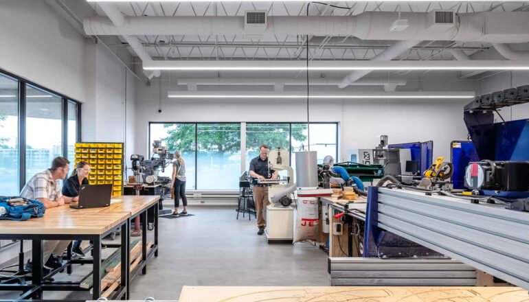 A student engineering work room with various types of machinery and abundant daylight.