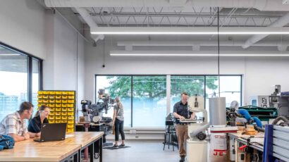 A student engineering work room with various types of machinery and abundant daylight.