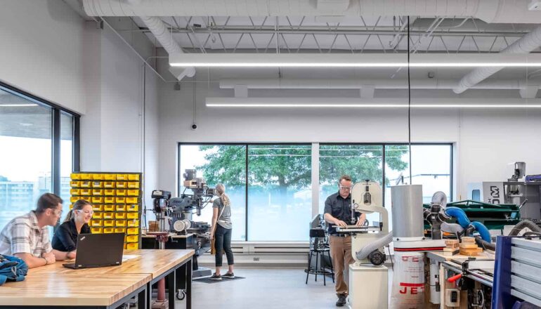 A student engineering work room with various types of machinery and abundant daylight.