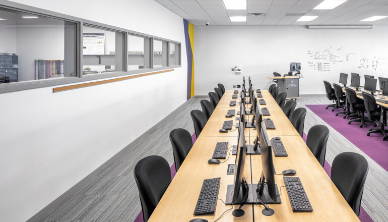 Classroom space with built-in computer stations and whiteboard walls.