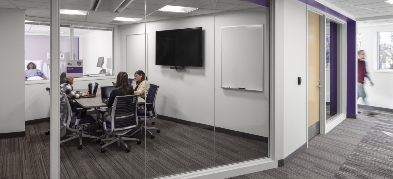 A student conference room with views into the adjacent classroom.