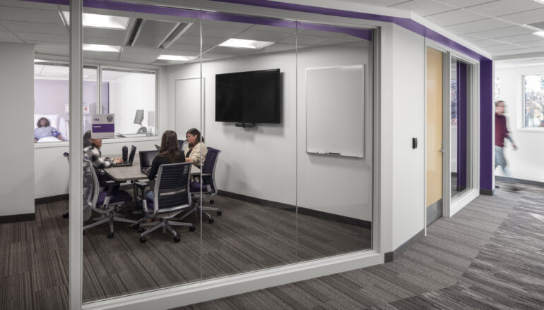 A student conference room with views into the adjacent classroom.