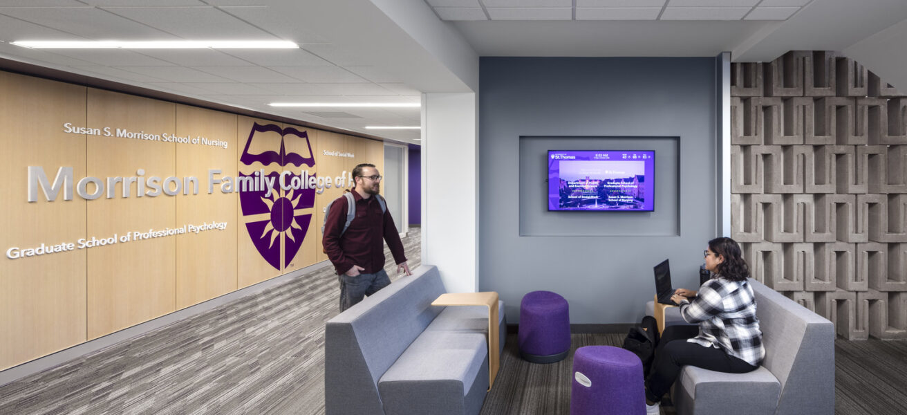 Students talk in the branded Morrison School of Health lower level lounge.