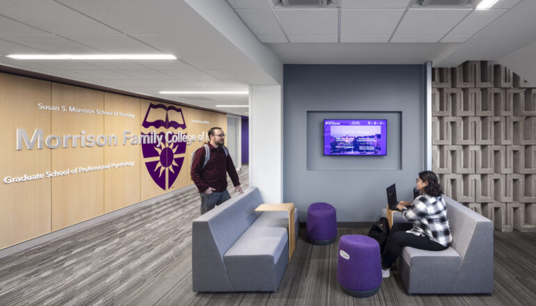 Students talk in the branded Morrison School of Health lower level lounge.