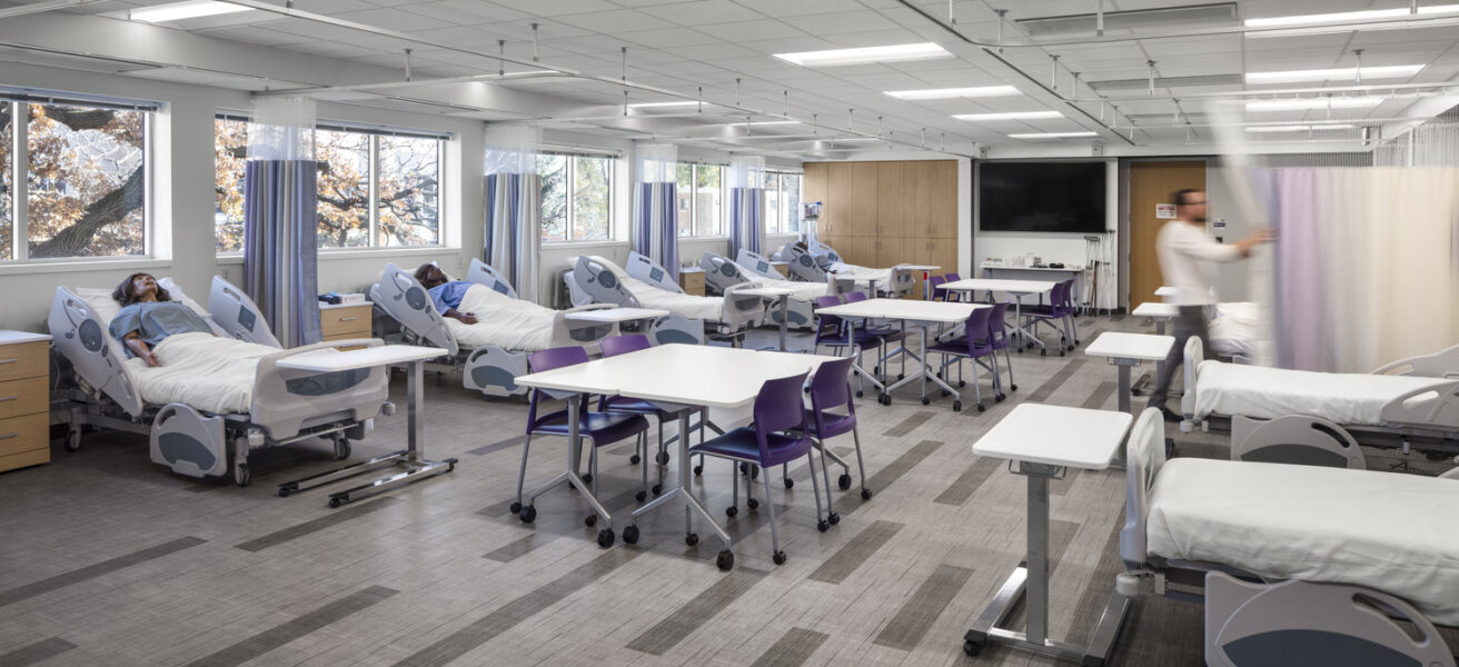 A view of a nursing simulation lab with numerous patient mannequins.