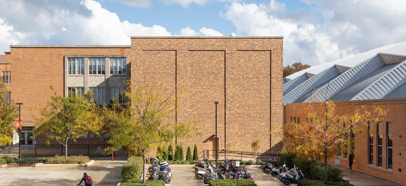 Overall exterior view of the high-bay materials lab and student moped parking area.