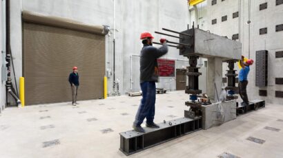 Engineering students adjust testing equipment in the structures lab.