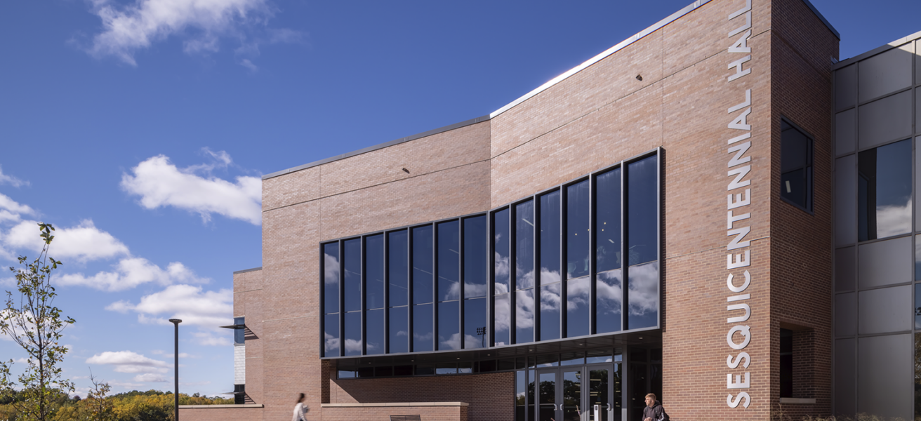 A focused view of Sesquicentennial Hall's main entry and exterior signage.