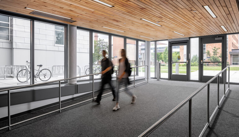 Two students walk down the entry ramp into North Residence Hall, which is ADA compliant and near student transportation and bike racks