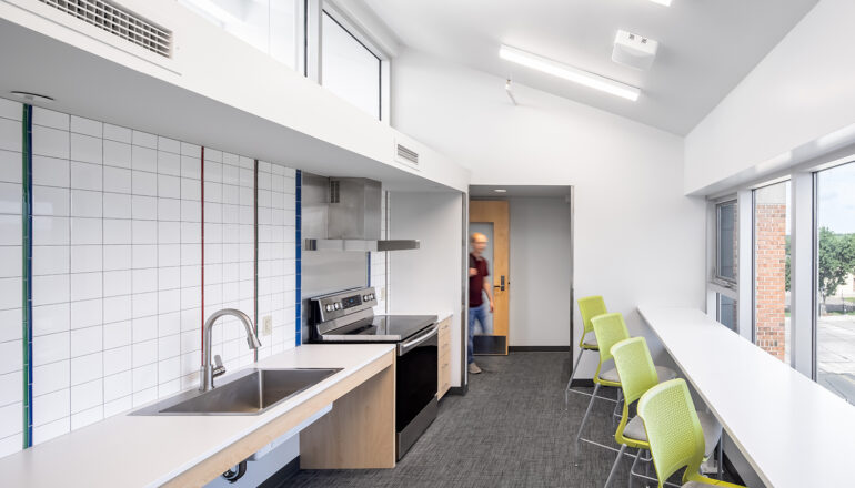 A shared student kitchen in North Residence Hall, with abundant natural light and adjacent study space