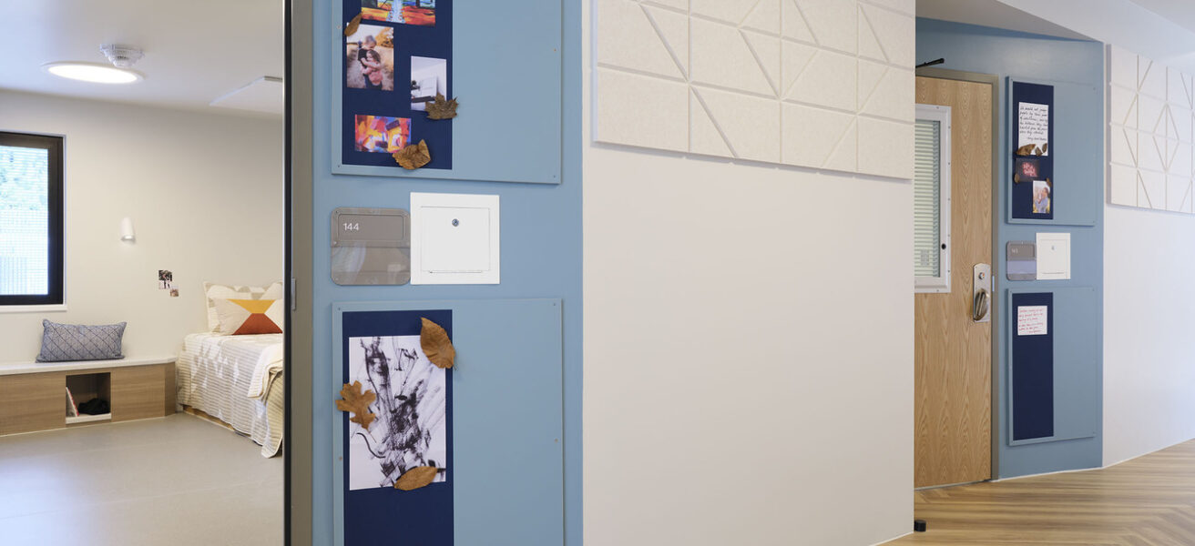 Corridor view into Maple Lane bedrooms with space for each patient to customize their doorway.