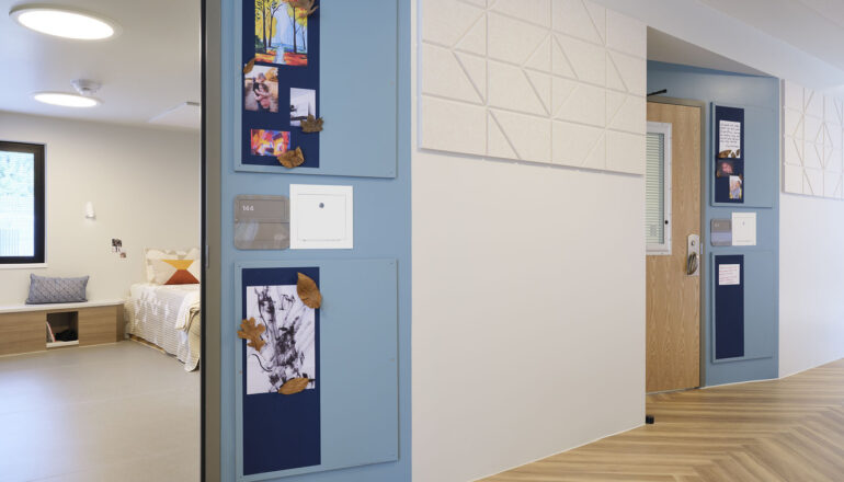 Corridor view into Maple Lane bedrooms with space for each patient to customize their doorway.