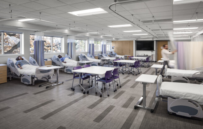 A view of a nursing simulation lab with numerous patient mannequins.